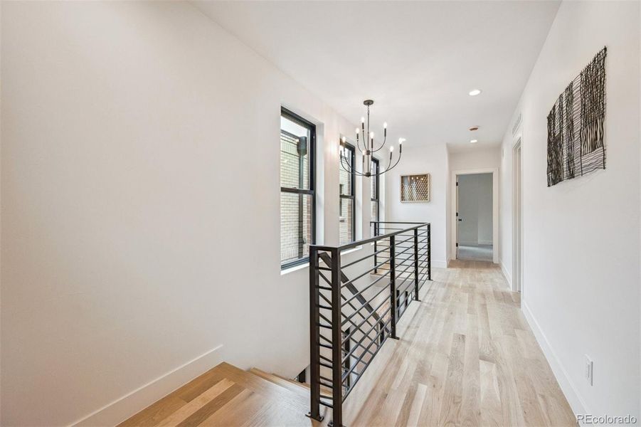 Custom floating oak and steel stairs take you up to the second floor