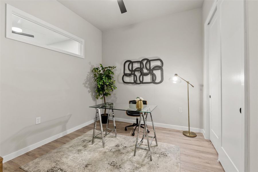 Home office with a ceiling fan and light wood-style flooring
