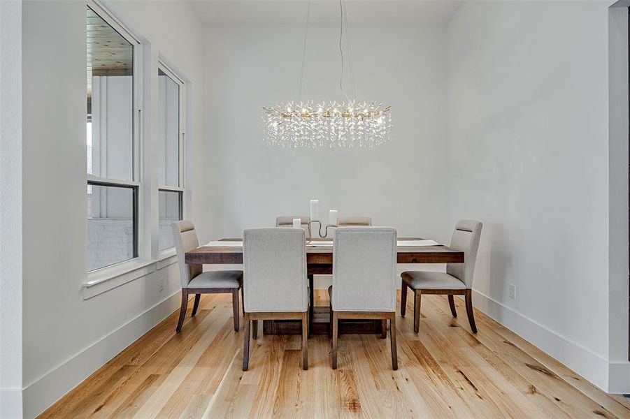 Dining area featuring light wood finished floors and a chandelier Dining area featuring light wood finished floors and a chandelier