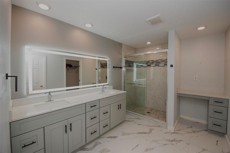En suite bathroom with custom touch lighting surrounding the mirror and fabulous large walk in shower. There is also a built in separate vanity as well as walk in closet. En suite bathroom with custom touch lighting surrounding the mirror and fabulous large walk in shower. There is also a built in separate vanity as well as walk in closet.