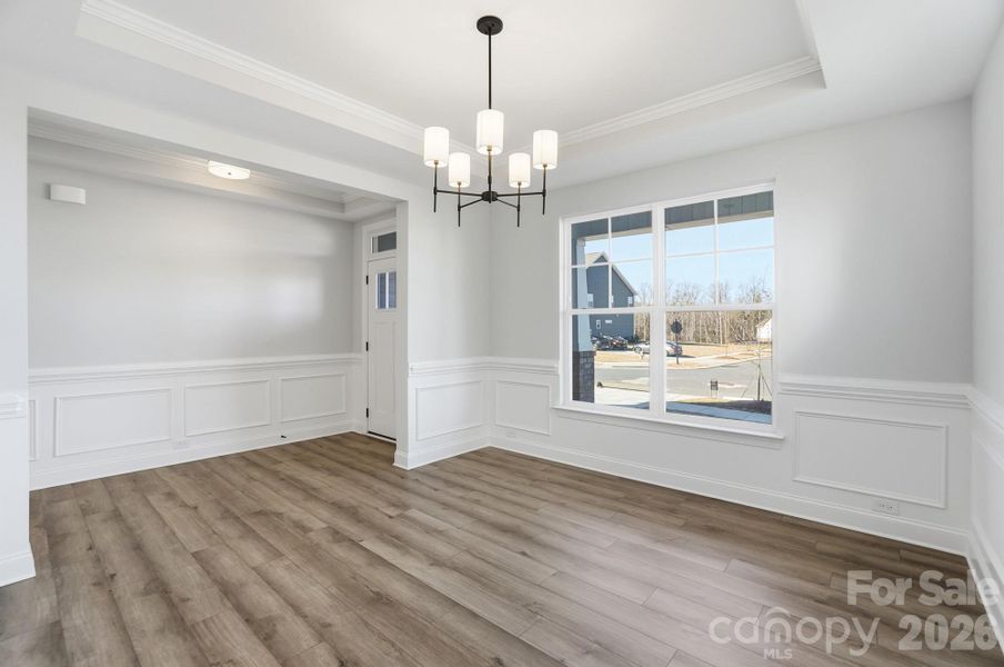 Dining room with tray ceiling and wainscoting