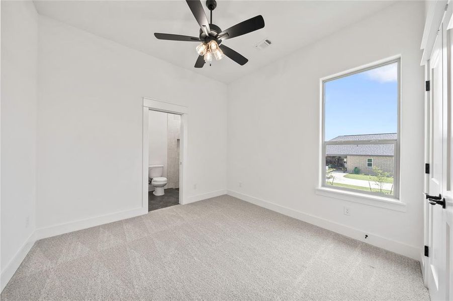 Empty room featuring carpet and a ceiling fan Empty room featuring carpet and a ceiling fan
