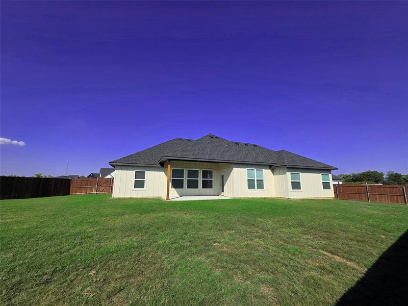 Back of property featuring a fenced backyard, a patio, and a shingled roof Back of property featuring a fenced backyard, a patio, and a shingled roof