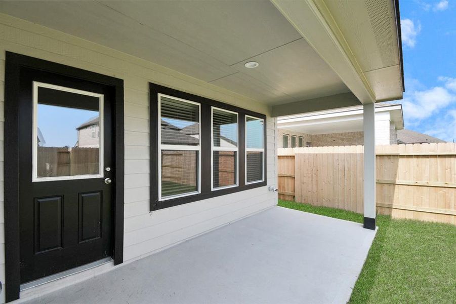 Discover the charm of this spacious backyard featuring a delightful covered patio. With ample room for both play and relaxation, it's the perfect outdoor haven. Sample photo of completed home. Actual color and selections may vary.