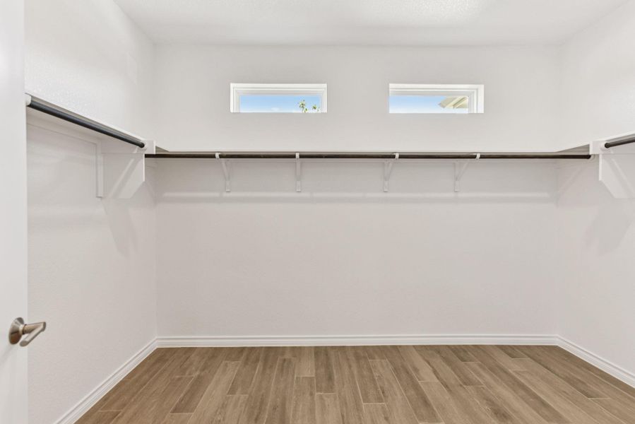 Spacious closet with light wood-type flooring Spacious closet with light wood-type flooring