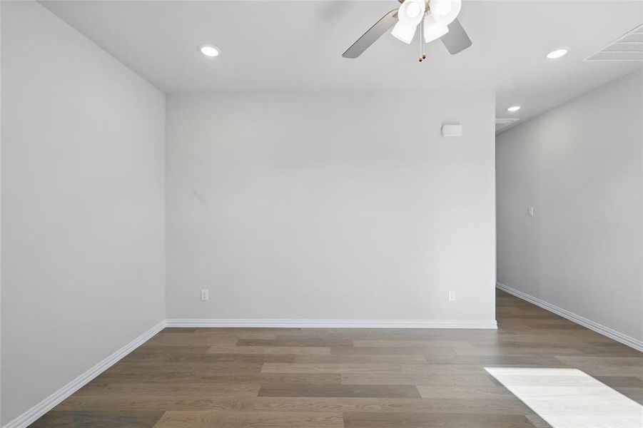 Spare room featuring wood finished floors, a ceiling fan, and recessed lighting Spare room featuring wood finished floors, a ceiling fan, and recessed lighting