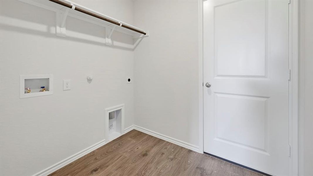 Laundry room featuring hookup for a gas dryer, wood finished floors, washer hookup, and electric dryer hookup