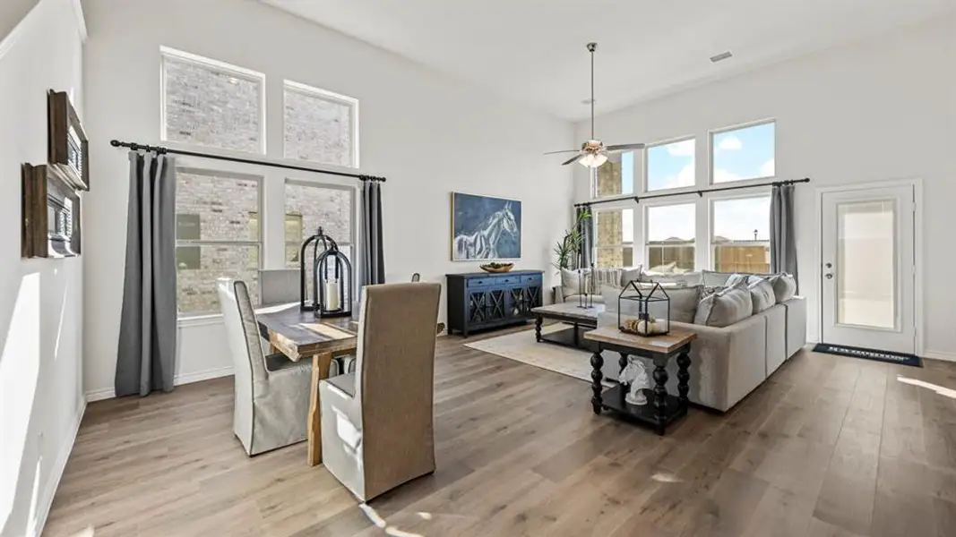Spacious open-concept living area featuring a vaulted ceiling and wood-finish flooring