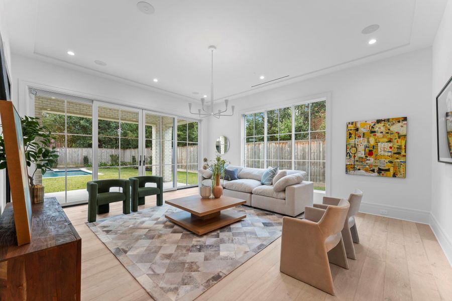 Another perspective of the family room, illuminated by expansive floor-to-ceiling windows. Another perspective of the family room, illuminated by expansive floor-to-ceiling windows.