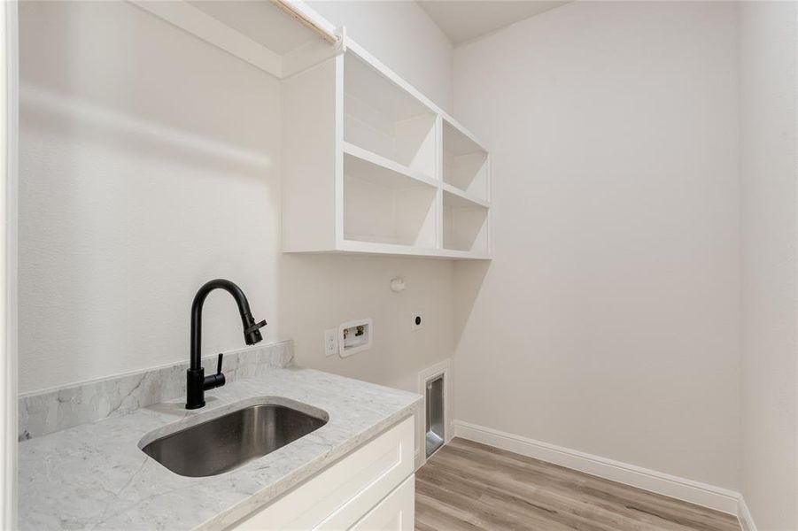 Washroom with washer hookup, light wood-style flooring, hookup for an electric dryer, and gas dryer hookup