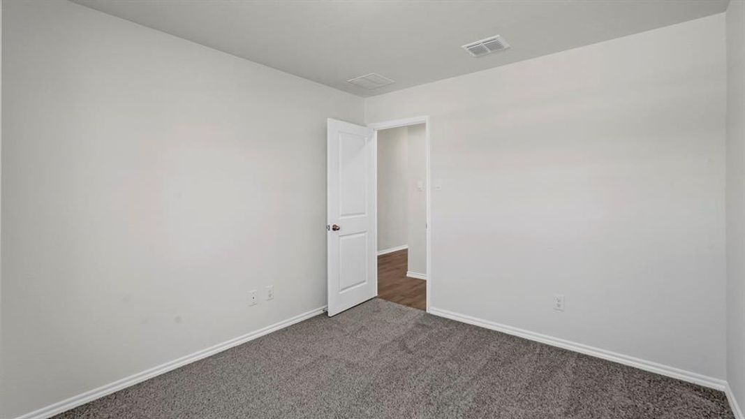 Carpeted interior room featuring light-colored walls and white trim