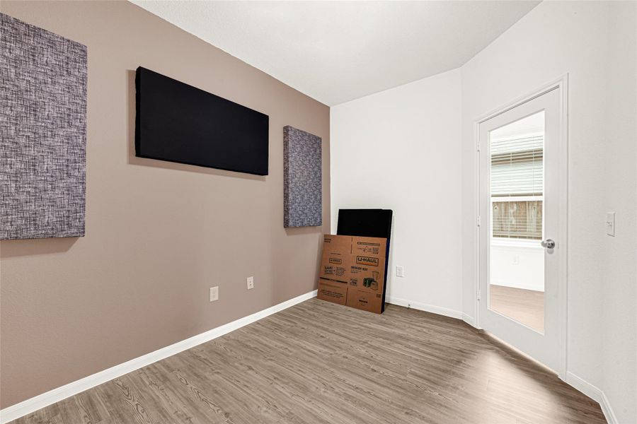 Cozy media room or secondary living area featuring a custom dark wood accent wall panel.