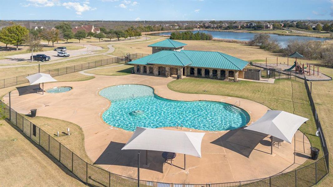 Community pool with a patio area, an in-ground hot tub, and a water view