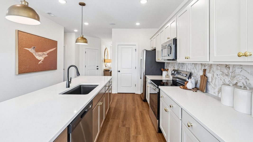 Kitchen with tile backsplash, pendant lighting, and quartz countertops Kitchen with tile backsplash, pendant lighting, and quartz countertops