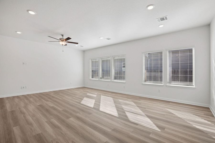 Empty room featuring light wood-style flooring, ceiling fan, and recessed lighting
