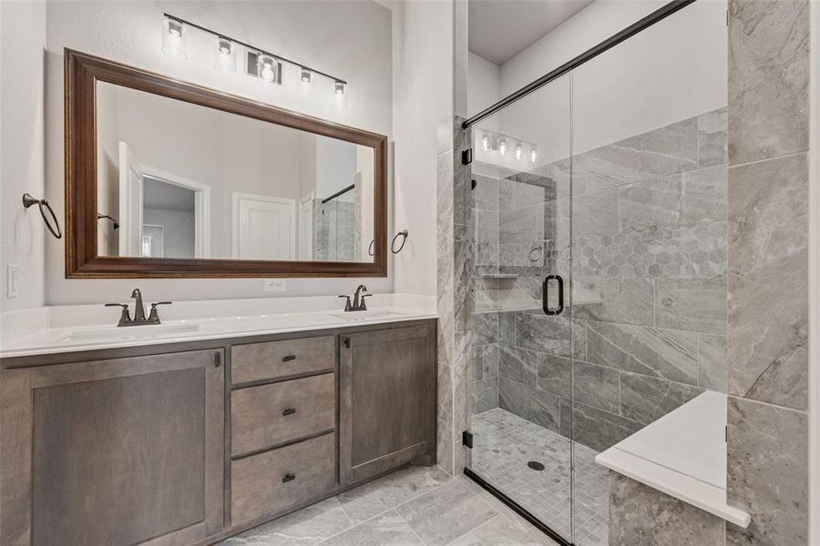 Full bathroom with a shower stall, double vanity, and light tile patterned floors Full bathroom with a shower stall, double vanity, and light tile patterned floors