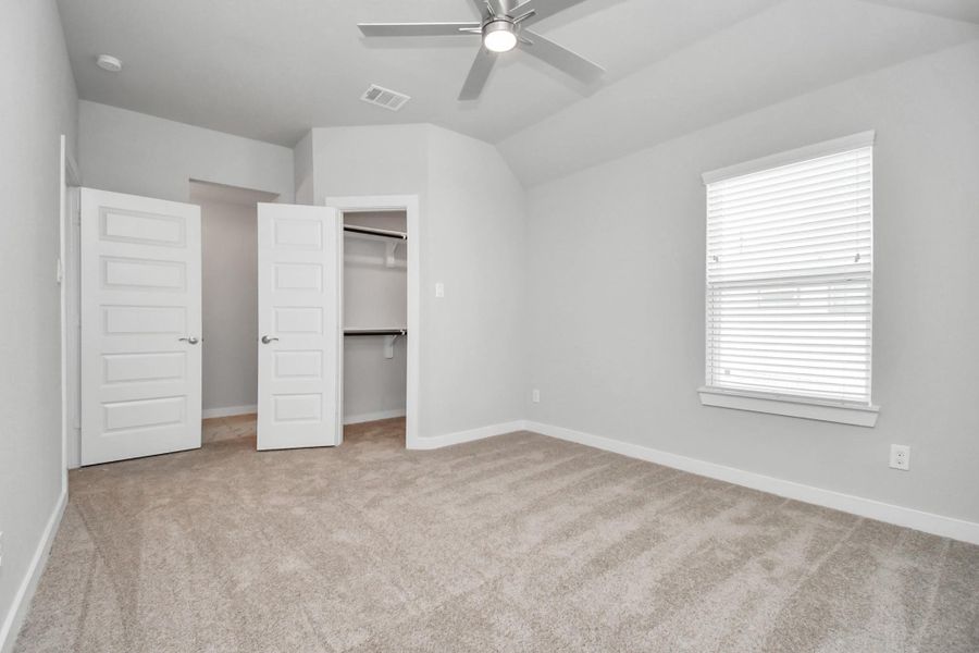 Elegance meets functionality in the generously sized secondary bedrooms, showcasing 5-panel doors with modern hardware, large windows adorned with privacy blinds, and spacious closets boasting sleek and contemporary finishes. Sample photo of completed home with similar floor plan. Actual colors and selections may vary. Elegance meets functionality in the generously sized secondary bedrooms, showcasing 5-panel doors with modern hardware, large windows adorned with privacy blinds, and spacious closets boasting sleek and contemporary finishes. Sample photo of completed home with similar floor plan. Actual colors and selections may vary.