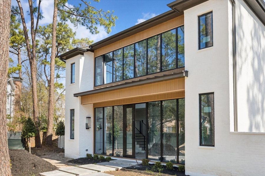 Elegant front entrance with fluted wood panelling, and expansive windows.