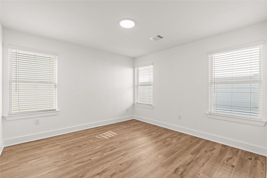 Crisp, clean canvas. The uniform neutral walls and warm wood-look flooring allow a buyer to easily customize this room to fit any design aesthetic.
