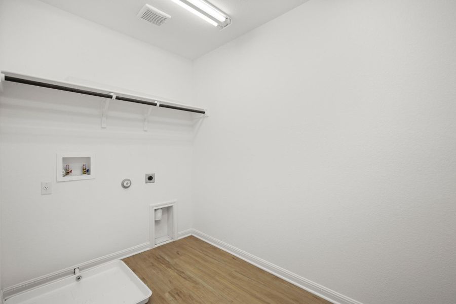 Laundry area featuring hookup for a gas dryer, hookup for an electric dryer, washer hookup, and light wood finished floors