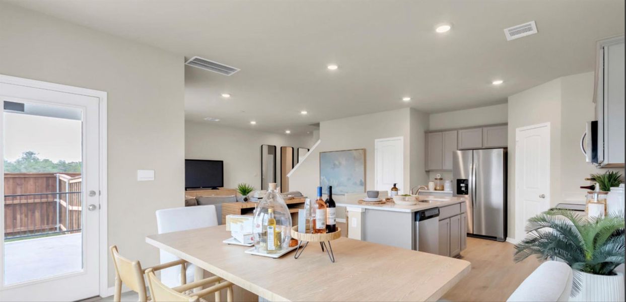 Dining space with light wood finished floors and recessed lighting