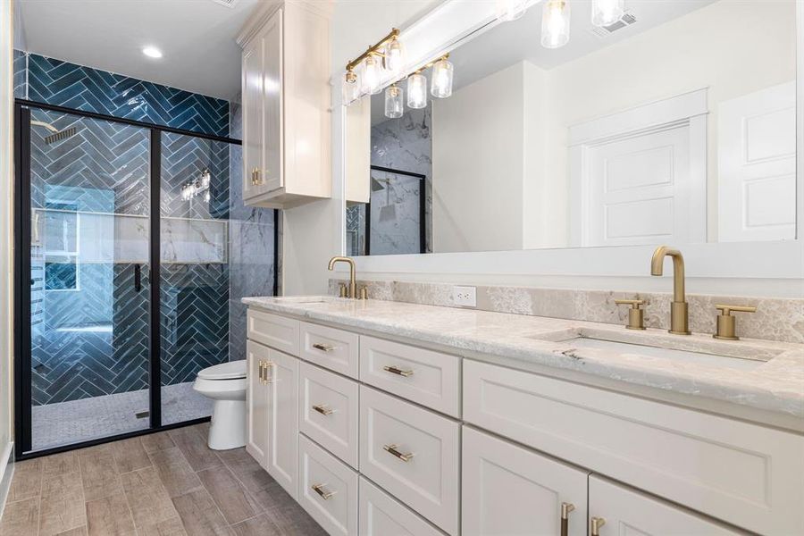 Bathroom with hardwood / wood-style floors, vanity, toilet, and a shower with door