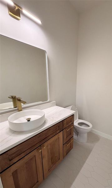 Half bath with vanity and light tile patterned floors