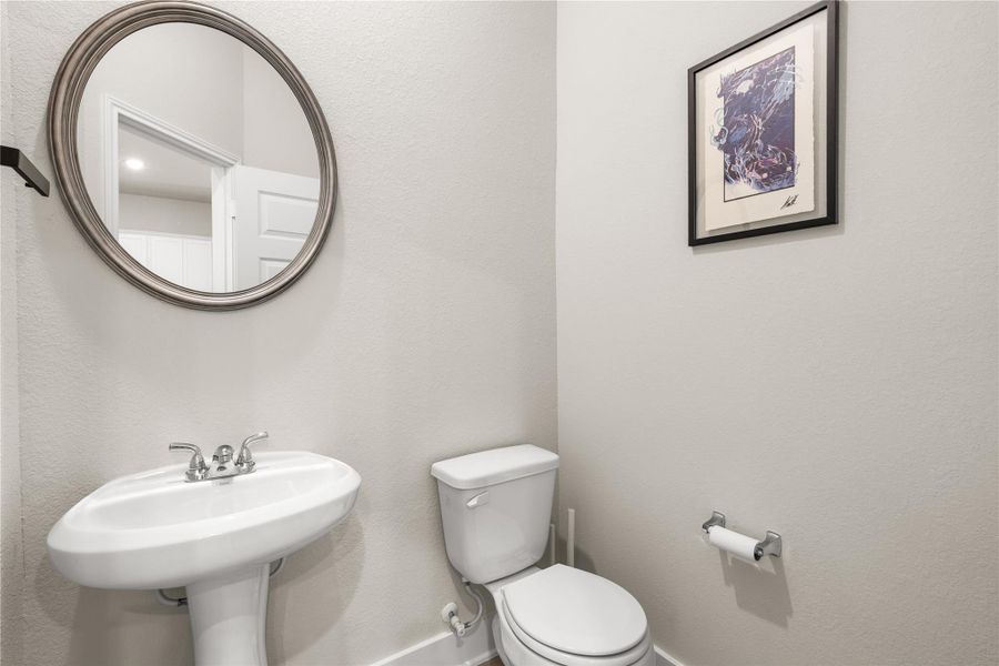 Conveniently located on the first floor, the powder bath allows guests easy access without disrupting the privacy of the home's upstairs living quarters.