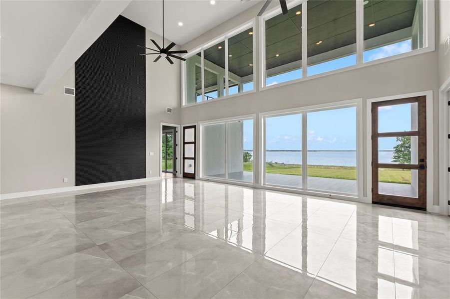 Soaring ceilings, clean modern lines, and uninterrupted lake views define the main living area.