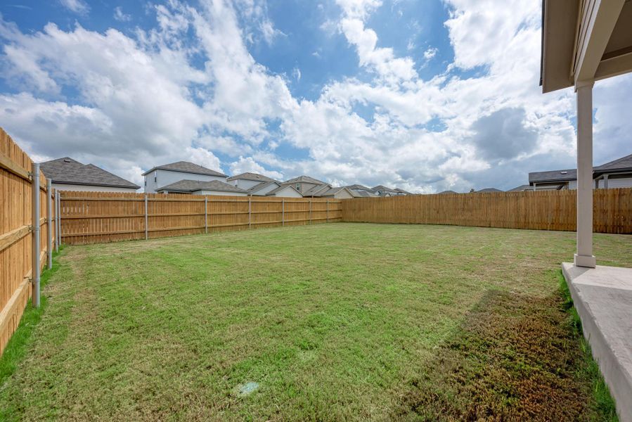 A spacious, enclosed backyard offers ample room for recreation and privacy.