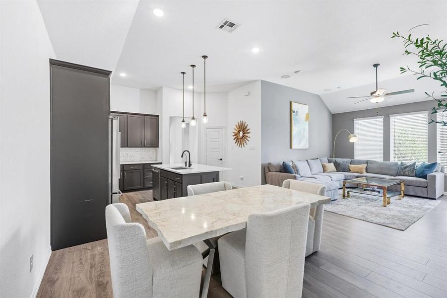 Dining room featuring vaulted ceiling, light wood-style floors, a ceiling fan, and recessed lighting