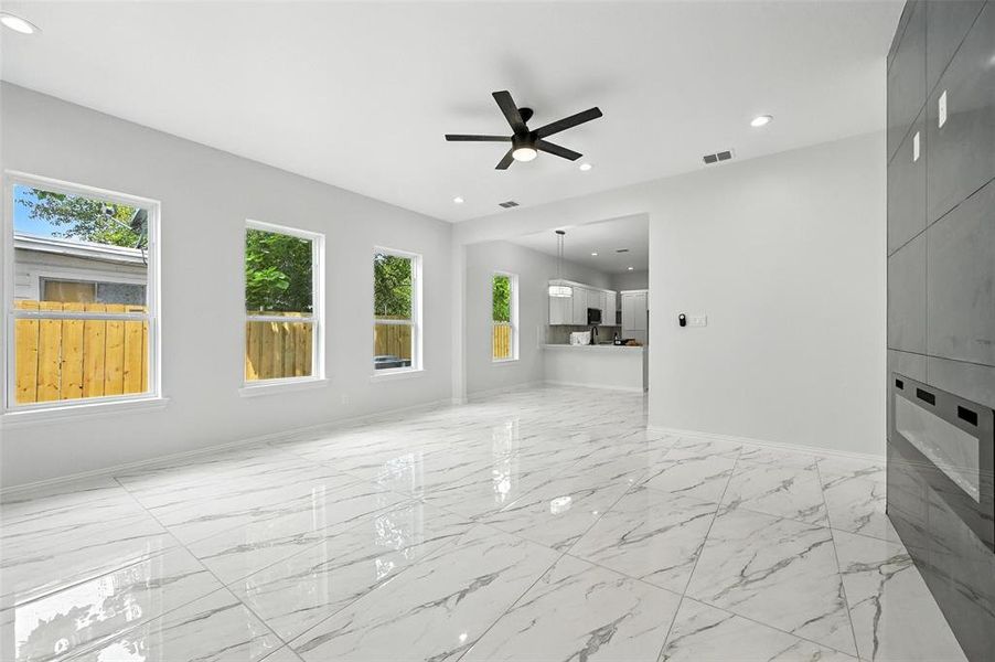 Unfurnished living room featuring light marble finish floors, recessed lighting, and ceiling fan