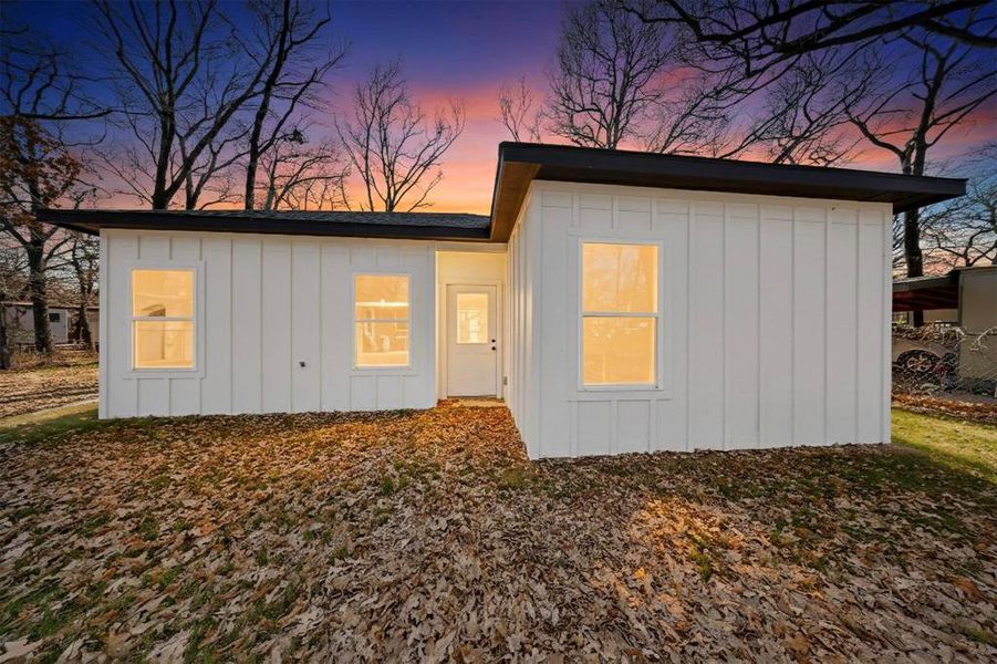 Rear view of property with board and batten siding