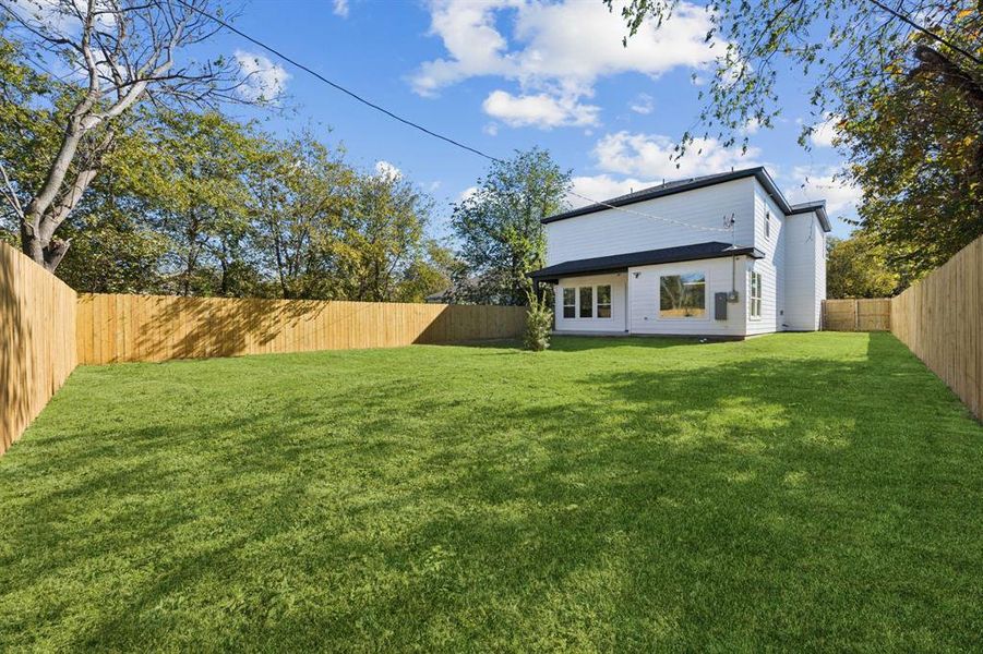 Rear view of property featuring a fenced backyard