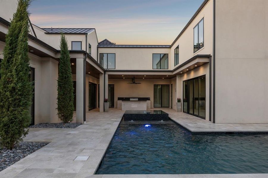 Back of house featuring area for grilling, a standing seam roof, a metal roof, a patio, and ceiling fan Back of house featuring area for grilling, a standing seam roof, a metal roof, a patio, and ceiling fan