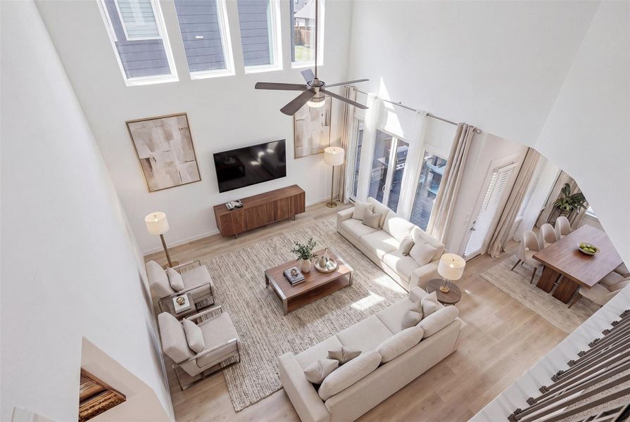 This elevated vantage point from the upstairs balcony overlooks the living room, sliding glass doors and dining room, showcasing the home’s open layout and seamless flow between spaces. *virtually staged