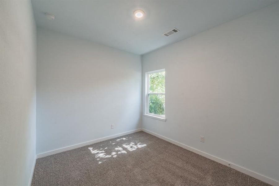 Empty room with a smoke detector and carpet floors Empty room with a smoke detector and carpet floors