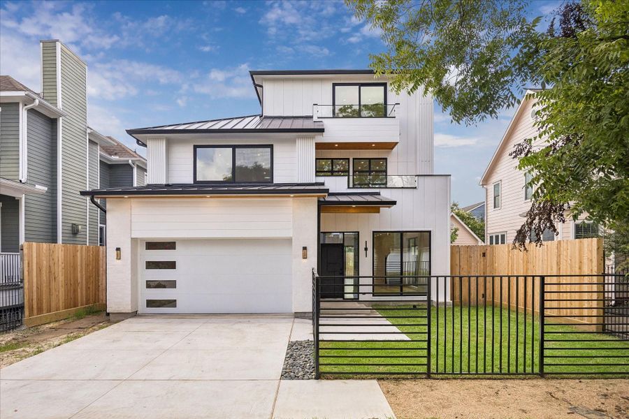 Architecturally designed home with clean lines and expansive windows. A custom iron gate enhances the home’s modern aesthetic while providing privacy. Architecturally designed home with clean lines and expansive windows. A custom iron gate enhances the home’s modern aesthetic while providing privacy.