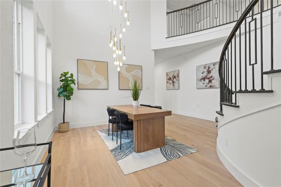 Office area with light wood-type flooring and a high ceiling Office area with light wood-type flooring and a high ceiling