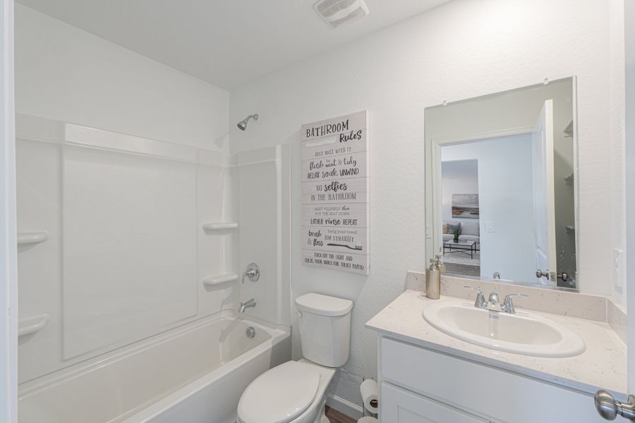 A bathroom with a sign on the wall. A bathroom with a sign on the wall.