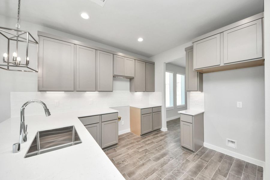 Discover another perspective of this stunning kitchen, generously appointed with an abundance of counter space. Sample photo of completed home with similar floor plan. Actual colors and selections may vary. Discover another perspective of this stunning kitchen, generously appointed with an abundance of counter space. Sample photo of completed home with similar floor plan. Actual colors and selections may vary.