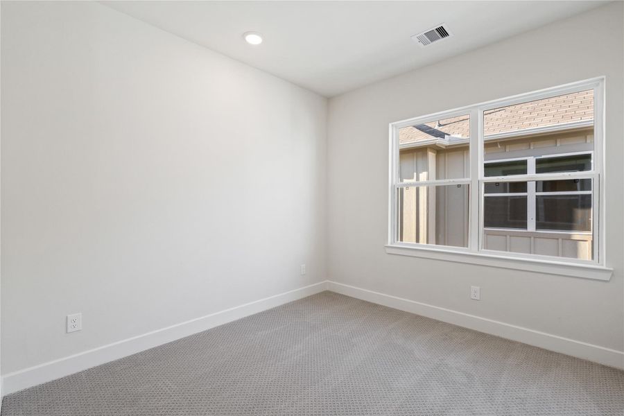 Third bedroom with carpeted floors and a side-facing window that keeps the room feeling open without competing with any adjacent room. Third bedroom with carpeted floors and a side-facing window that keeps the room feeling open without competing with any adjacent room.