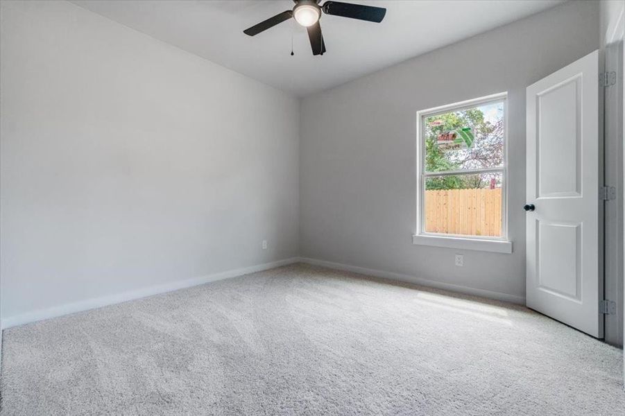 Carpeted spare room with ceiling fan