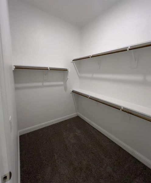 Spacious closet 2 in primary suite featuring painted wood shelves and rods