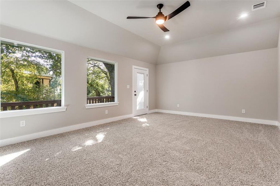 Carpeted spare room featuring vaulted ceiling, ceiling fan, and recessed lighting