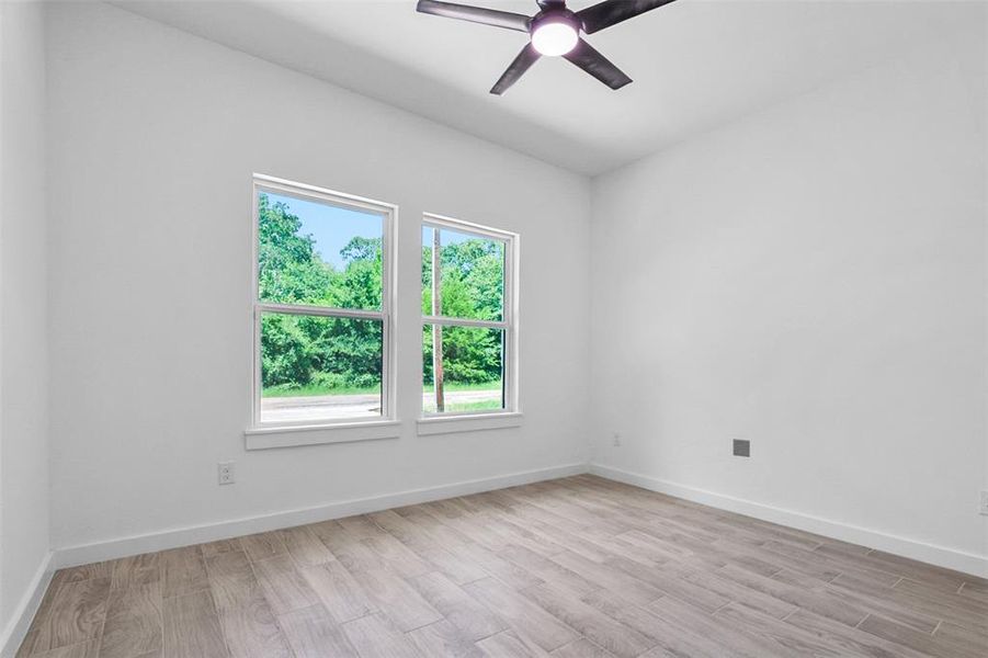 Spare room featuring light wood-type flooring and ceiling fan Spare room featuring light wood-type flooring and ceiling fan