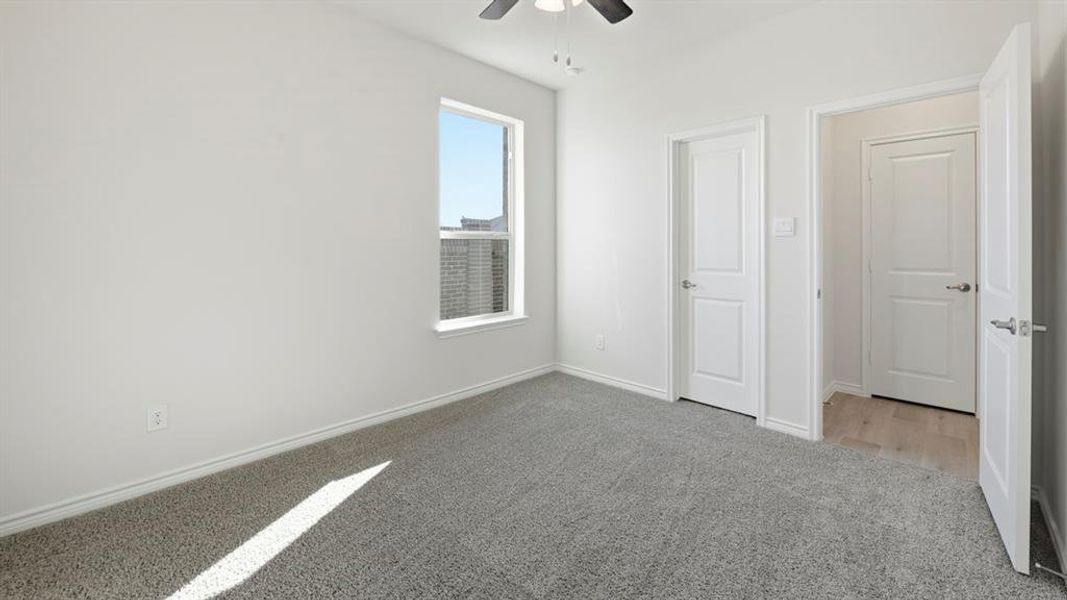 Unfurnished bedroom featuring light carpet and a ceiling fan