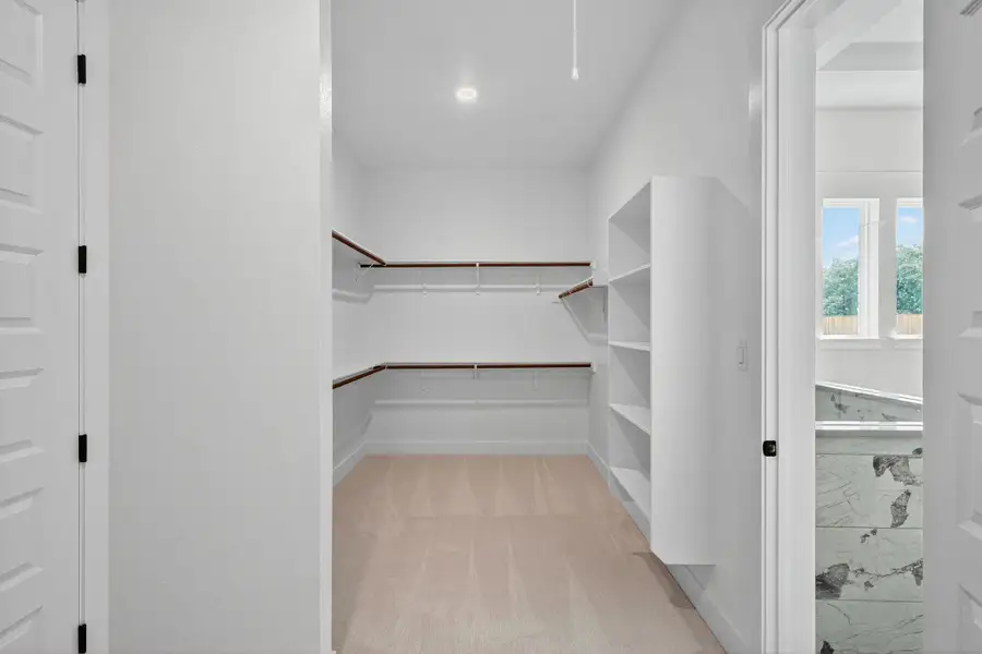 Walk in closet featuring light colored carpet Walk in closet featuring light colored carpet