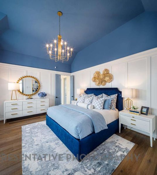 Bedroom with vaulted ceiling, a chandelier, and wood finished floors Bedroom with vaulted ceiling, a chandelier, and wood finished floors