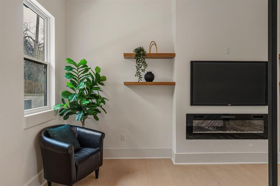 Living area with a glass covered fireplace and light wood finished floors